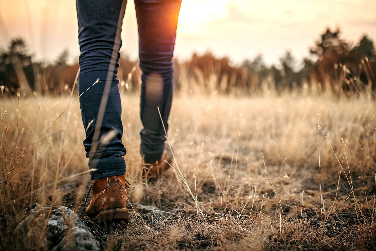 man walking through grass