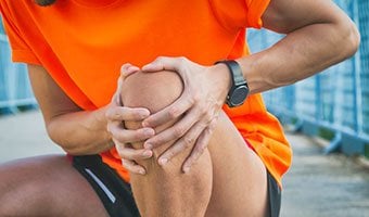 person holding knee in pain