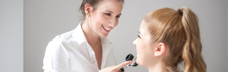 Dermatologist inspecting skin of teen 