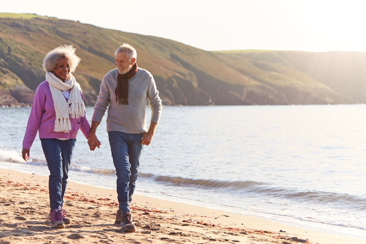 older couple walking on beach