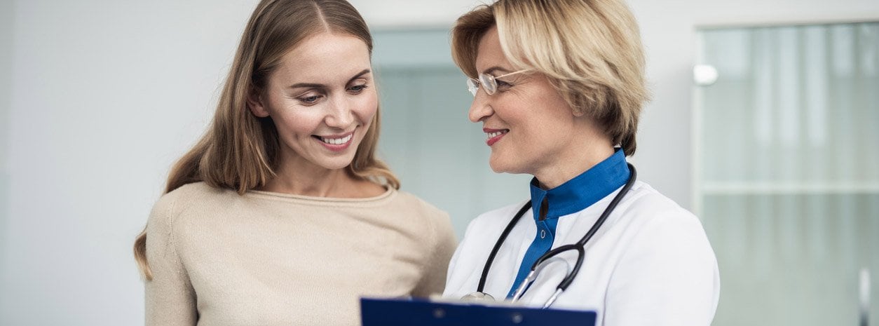 Woman doctor smiling at female patient