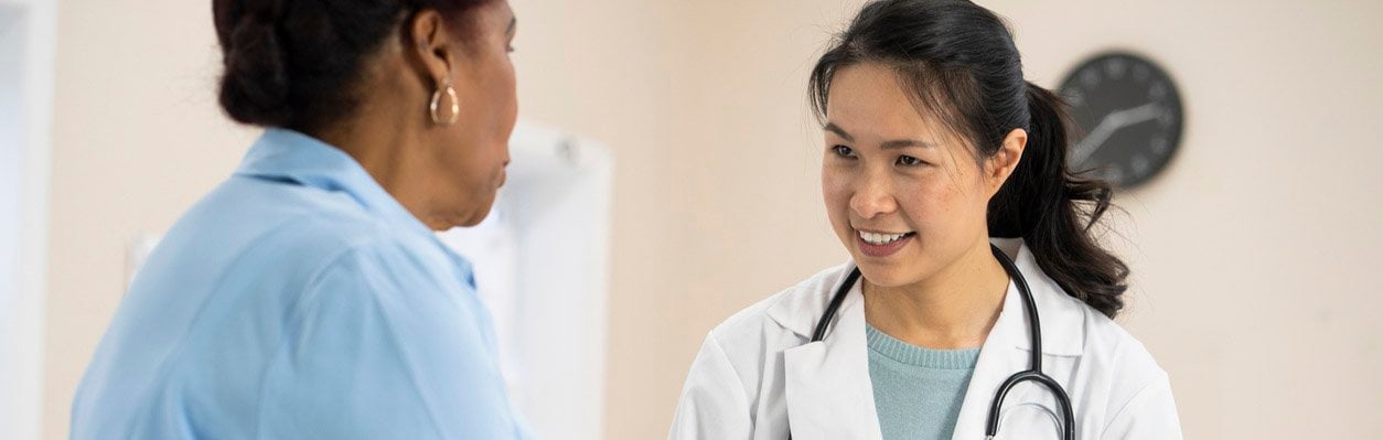 Physician smiling and talking with patient