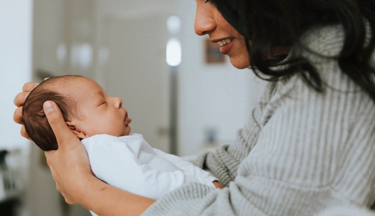 woman holding and admiring a newborn