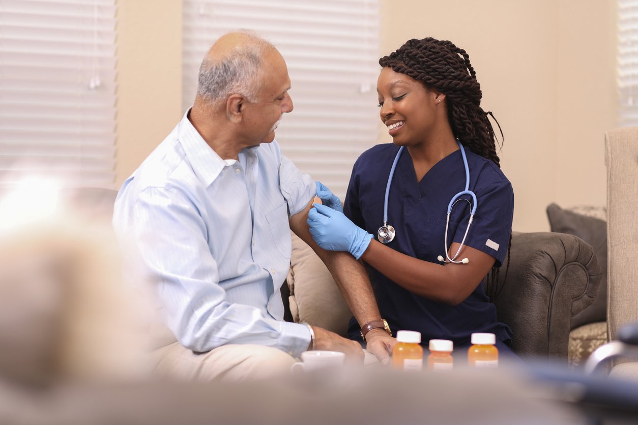 woman provider applying band-aide to patient's arm