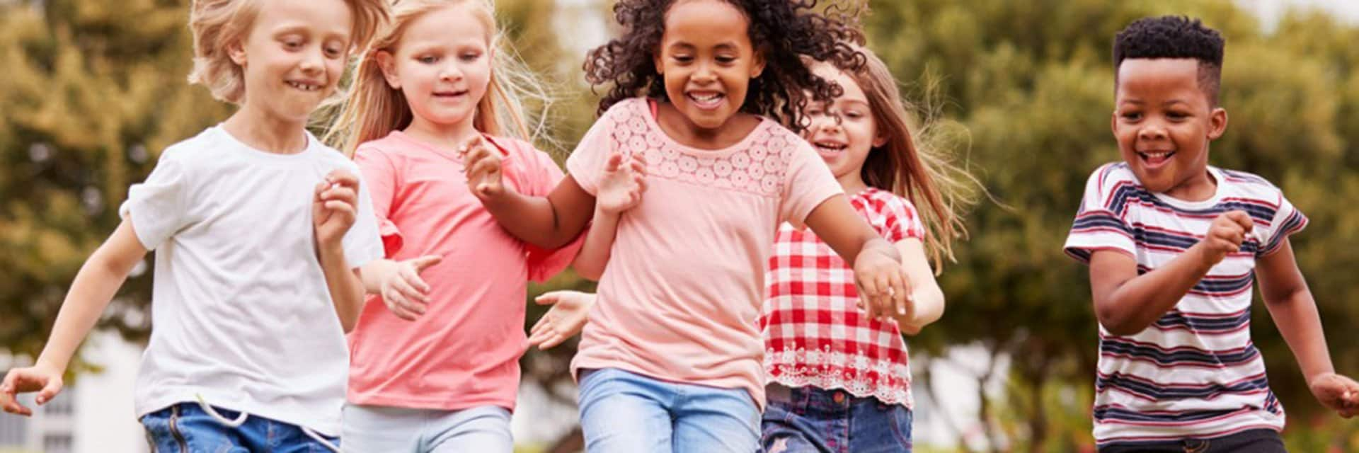 children chasing after a soccer ball