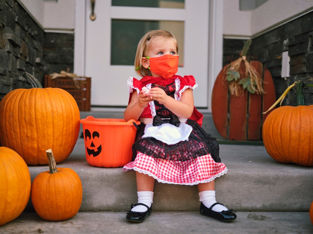 little girl in costume with face mask