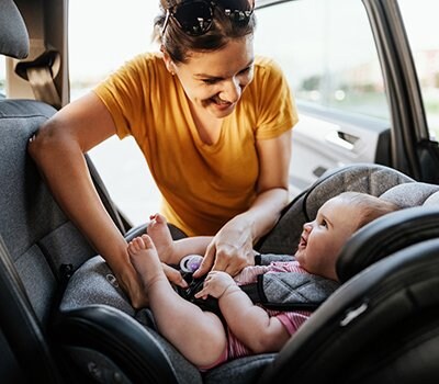 woman adjusting buckles on car seat