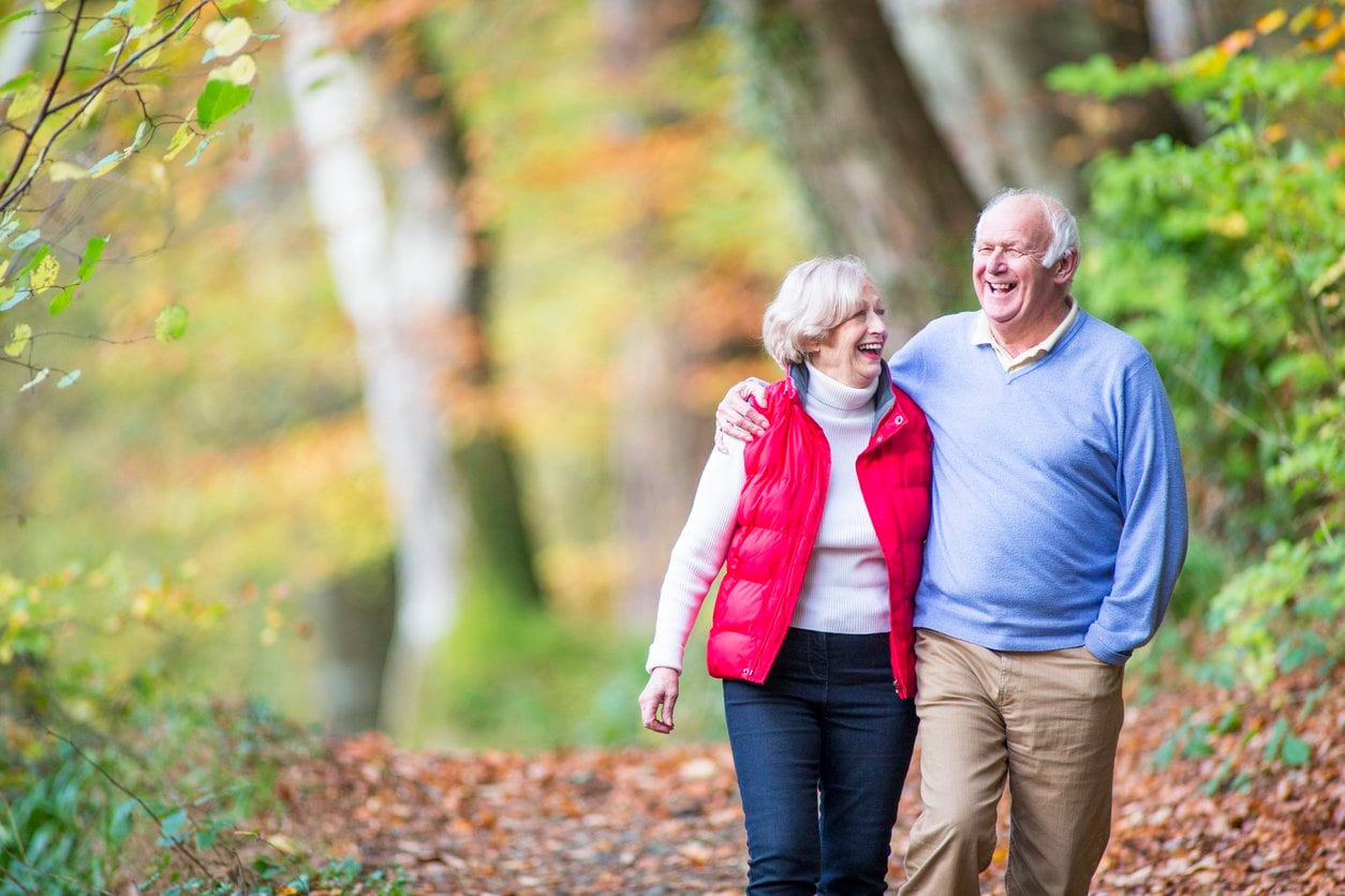 senior couple walking in woods